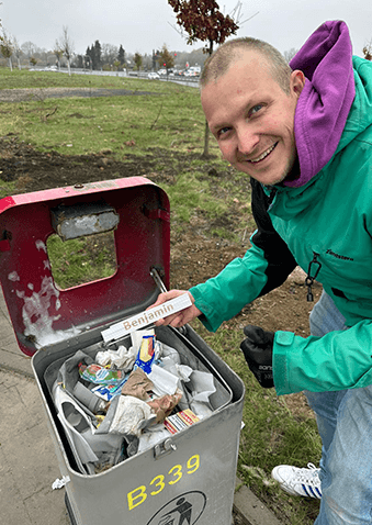 Technician installing IoT sensor on public waste bin in Hürth